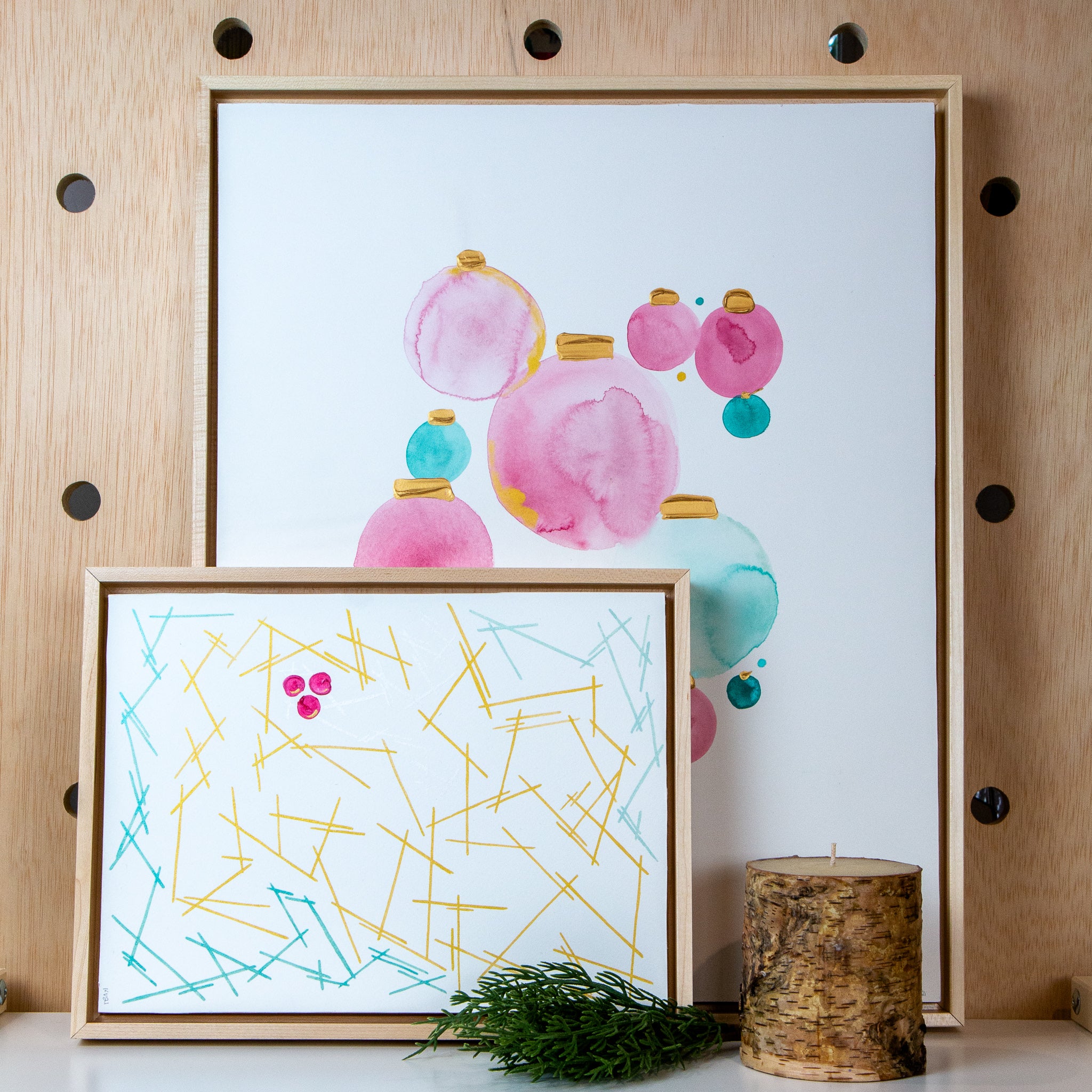 original artwork of abstract pine needles and berries, mixed media on paper float mounted in maple frame, paired with ornaments original artwork
